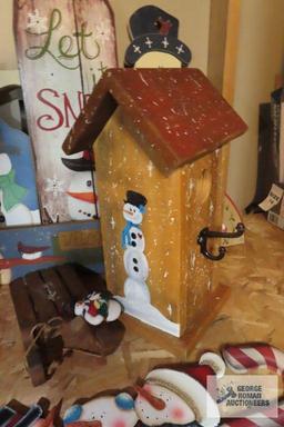 Christmas ornaments, snowman themed birdhouse, and other wooden decorations