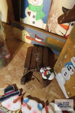 Christmas ornaments, snowman themed birdhouse, and other wooden decorations