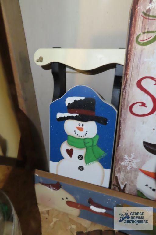 Christmas ornaments, snowman themed birdhouse, and other wooden decorations