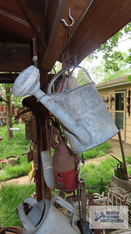 Lot of antique watering cans and birdhouse