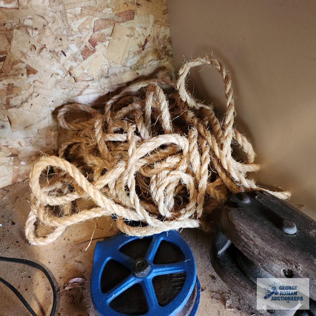 Metal and wooden antique pulleys with rope