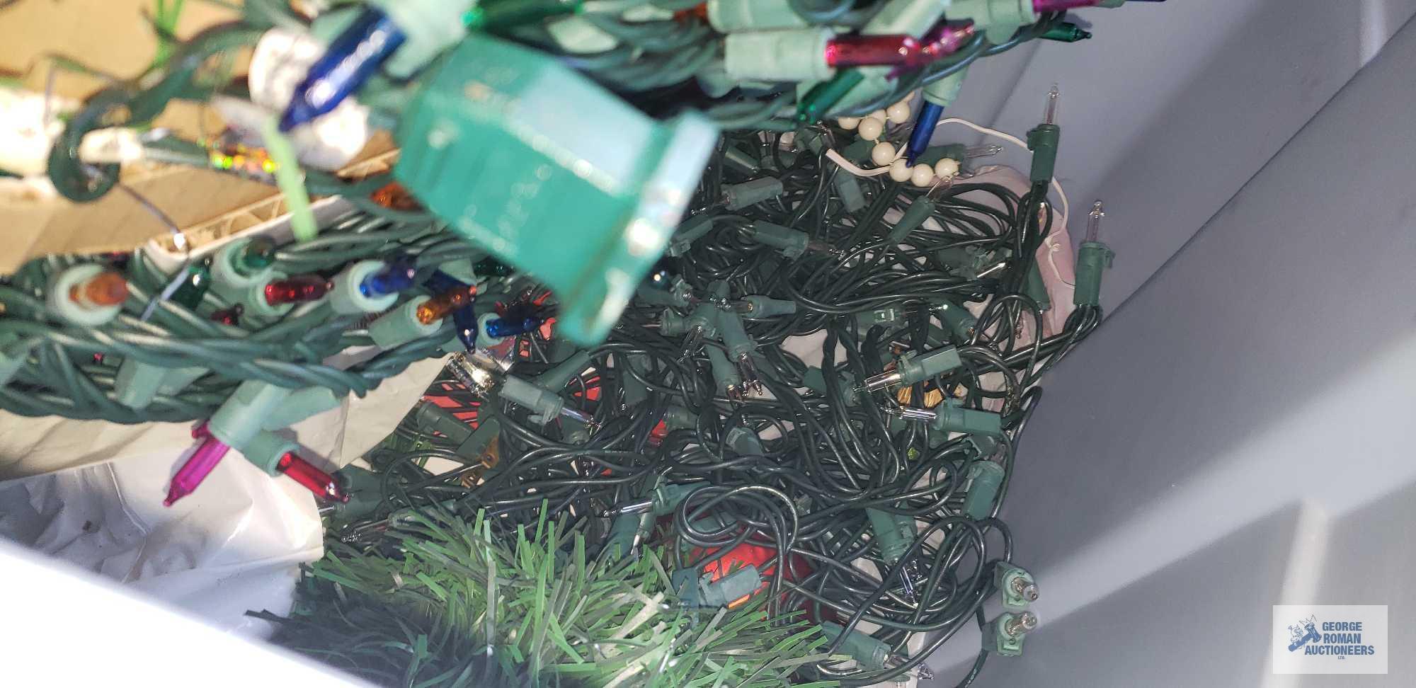 Tote of Christmas lights and garland and other plastic bin with electric cords