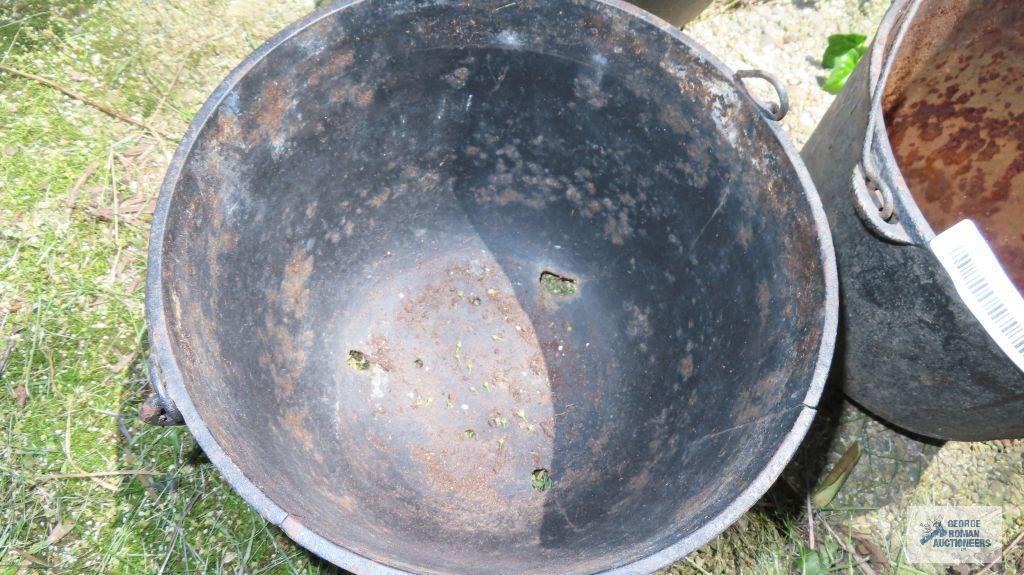 Cast iron cauldrons, one has holes