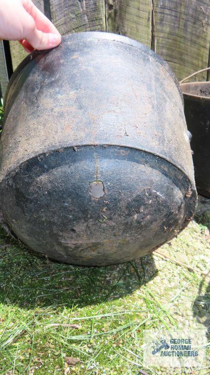 Cast iron cauldrons, one has holes