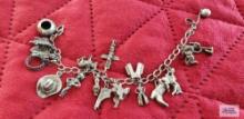 Silver colored charm bracelet with Native American and other charms, one marked Sterling, one marked