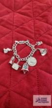 Monet silver colored charm bracelet with various charms, one marked Sterling