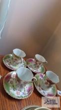 Four floral hand-painted cups and saucers