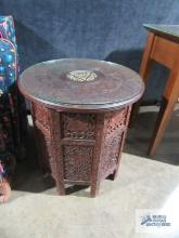 Ornate carved wood accent table with foldable base