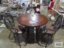 Wood and metal high top table with three padded metal swivel chairs