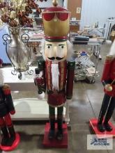 Wooden nutcracker holding another nutcracker, approximately 5 ft tall.