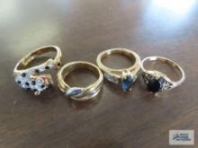 Three gemstone and one band ring marked 18K H.G.E.