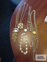 Variety of gold and white costume jewelry necklaces