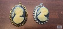 Two black and white cameo pendants. one needs repaired