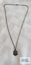 Silver colored religious pendant marked Sterling on silver colored chain, no marking found