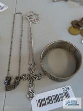 Silver colored cross necklace, floral bracelet, and Mary necklace