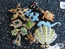 Variety of pins, including sea animals, seashells, palm trees, one marked Gerry's, one marked