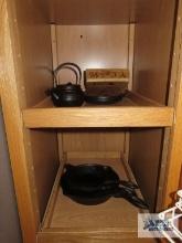 Cast iron skillets, small tea kettle with strainer, and warming plate
