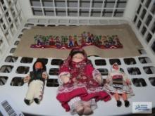Three assorted dolls and cloth banner