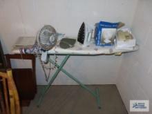 Ironing board with iron, desktop fan, and telephone in basement