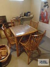 Bamboo style dinette set including four chairs and glass insert. in basement