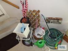 Garden hose with sprayer, dustpans, outdoor table, lattice, planters, watering can, etc