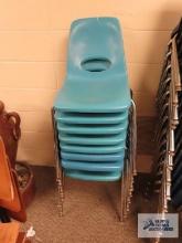 Eight light blue school chairs