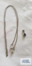 Silver colored pendant with purple stone, marked 925 and open-ended silver colored chain with clear