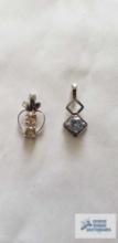 Silver colored pendant with pale blue stone, marked 925 and silver colored pendant with two yellow