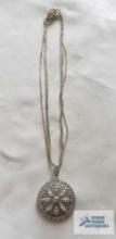 Silver colored pendant with clear gemstones, no markings found, on silver colored multi-strand