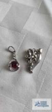 Silver colored floral pendant with clear stone, marked 925. Silver colored pendant with red stone,