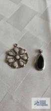 Silver colored white stone floral pendant, marked 925 and black stone pendant, no marking found