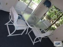 Glass top outdoor table with four armchairs. On first floor.