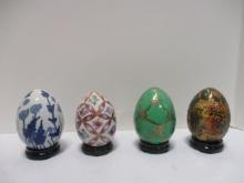 Four Decorative Porcelain Eggs on Wood Stands.