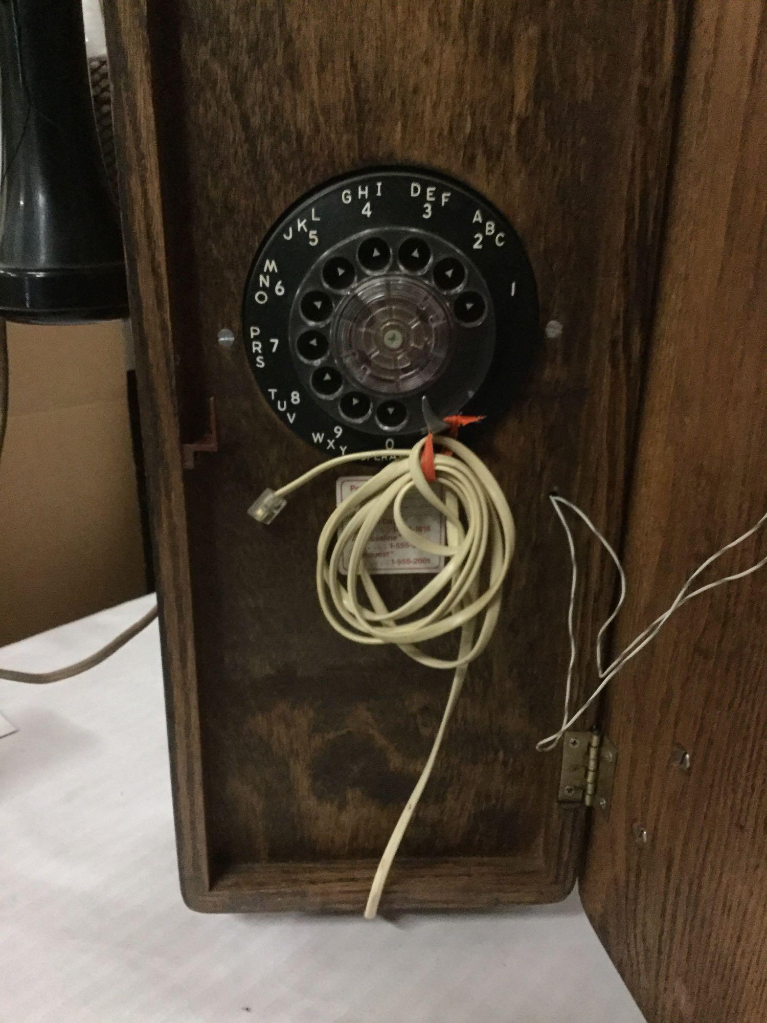 Vintage T.D.Y. Telephone Company hand crank type wood wall phone with dial, phone line, and extra