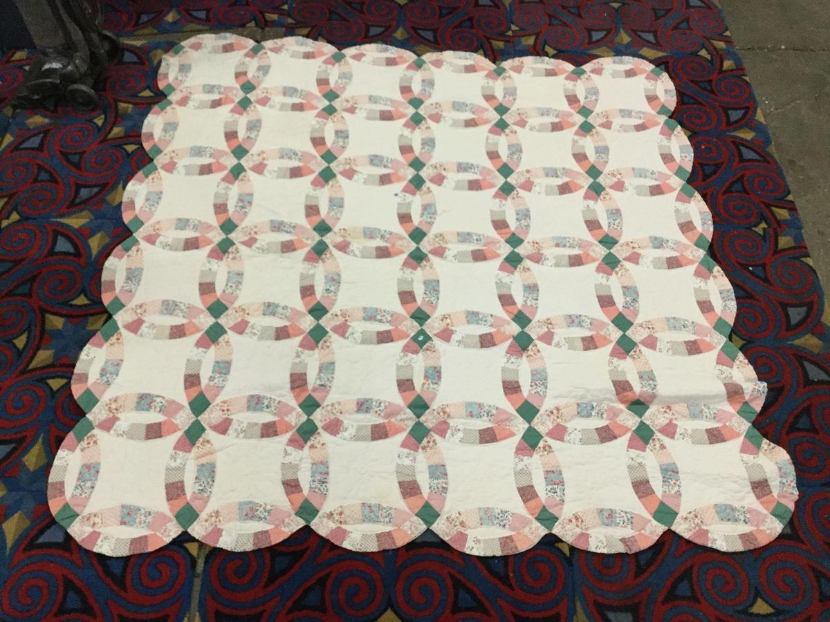 Large vintage hand made quilt feat. an overlapped circular pattern with some light wear