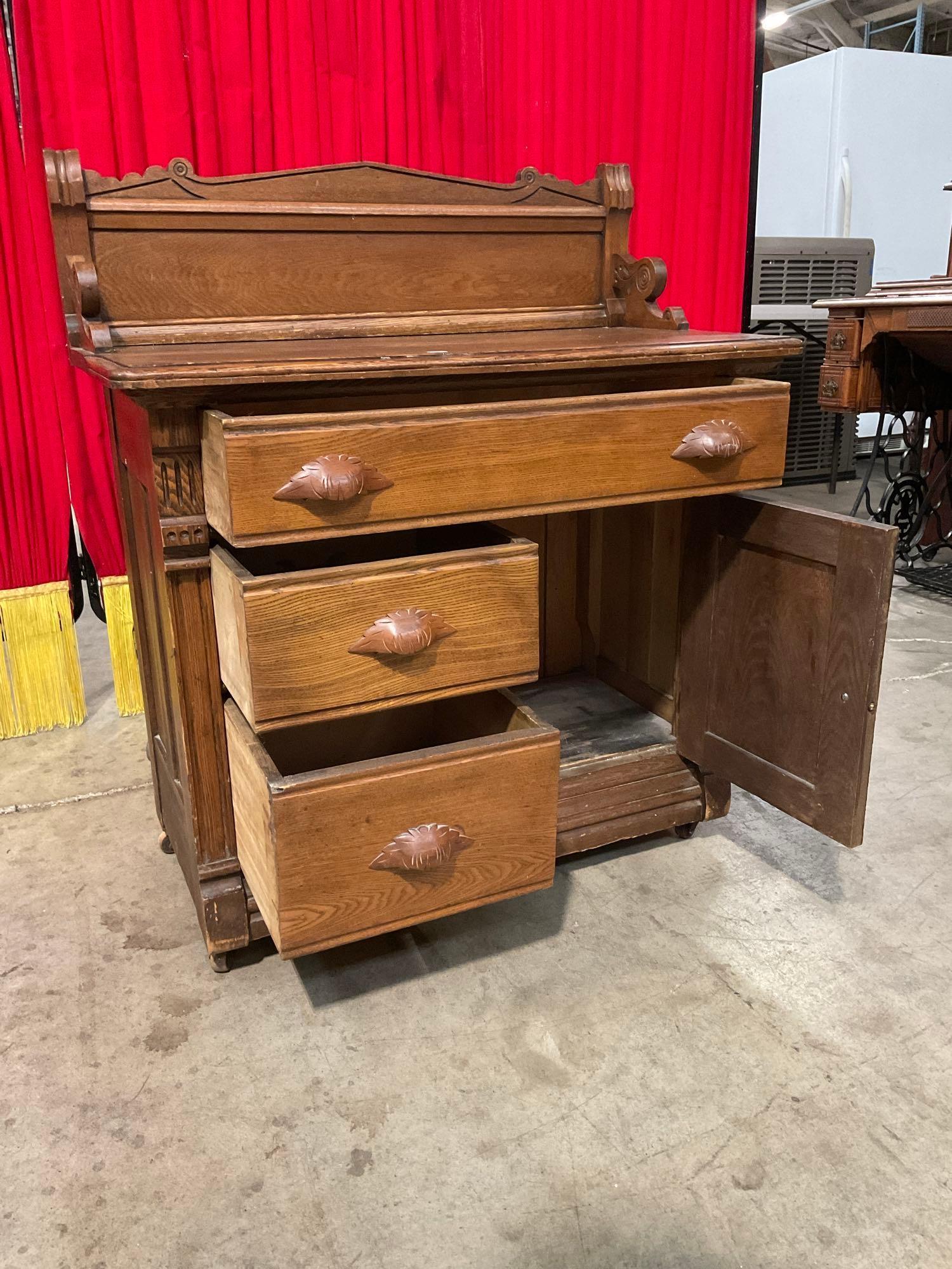 Antique Wheeled Wooden Commode w/ 3 Drawers, 1 Cupboard & Handsome Carved Details. See pics.