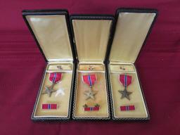 3 Bronze star medals in cases.