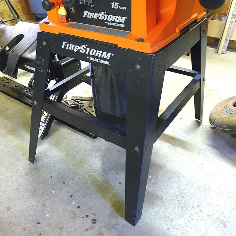Black and Decker FireStorm 10" table saw with steel floor stand and dust collection bag. Table with