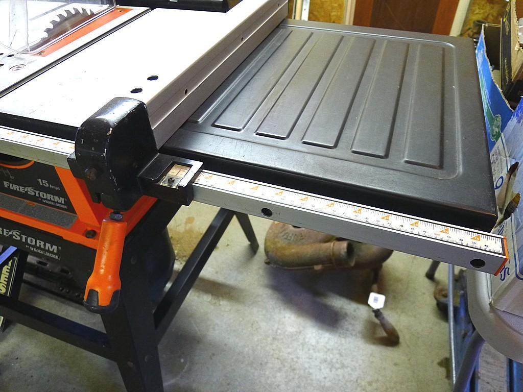 Black and Decker FireStorm 10" table saw with steel floor stand and dust collection bag. Table with
