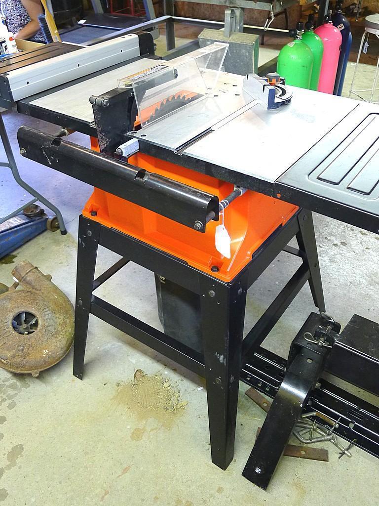 Black and Decker FireStorm 10" table saw with steel floor stand and dust collection bag. Table with