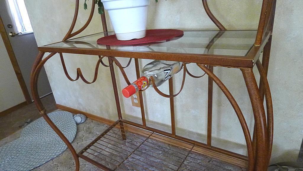 Metal framed wine rack with two glass shelves and a bottom wire shelf. Approx. 6' tall x 3' wide x
