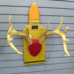 12 point whitetail antlers are mounted on a cartridge shaped plaque. Inside spread is 18", outside