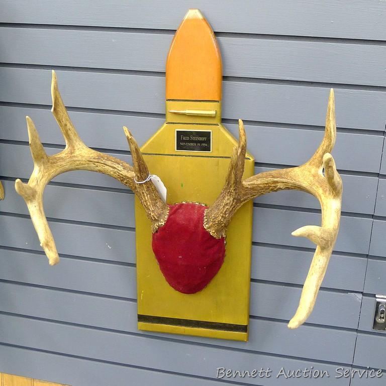 12 point whitetail antlers are mounted on a cartridge shaped plaque. Inside spread is 18", outside