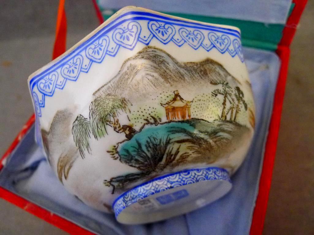 Egg shell porcelain Oriental octagonal bowl depicts mountain scene and comes with storage box. Bowl