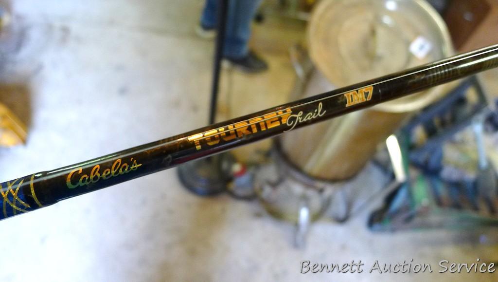 Two fishing rods with reels. One Cabela's Tourney Trail IM7 rod, one Mitchell graphite rod. One has