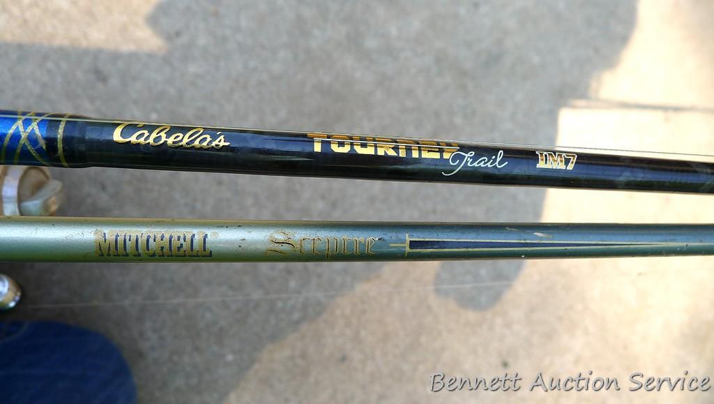 Two fishing rods with reels. One Cabela's Tourney Trail IM7 rod, one Mitchell graphite rod. One has