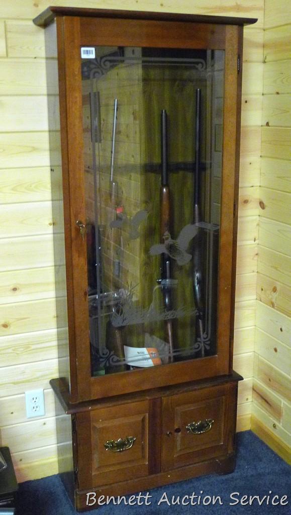 Wooden gun cabinet with two locking storage areas and etched glass door is approx. 29" x 11" x 72"