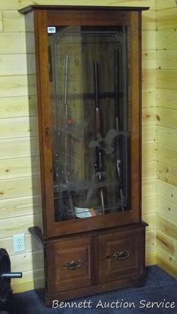 Wooden gun cabinet with two locking storage areas and etched glass door is approx. 29" x 11" x 72"