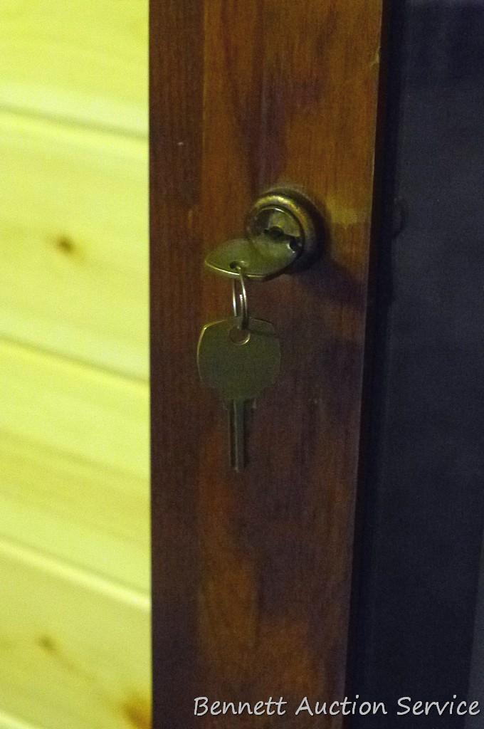 Wooden gun cabinet with two locking storage areas and etched glass door is approx. 29" x 11" x 72"