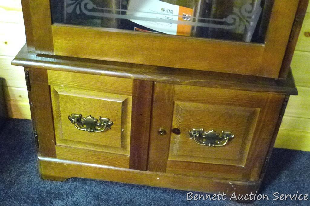 Wooden gun cabinet with two locking storage areas and etched glass door is approx. 29" x 11" x 72"